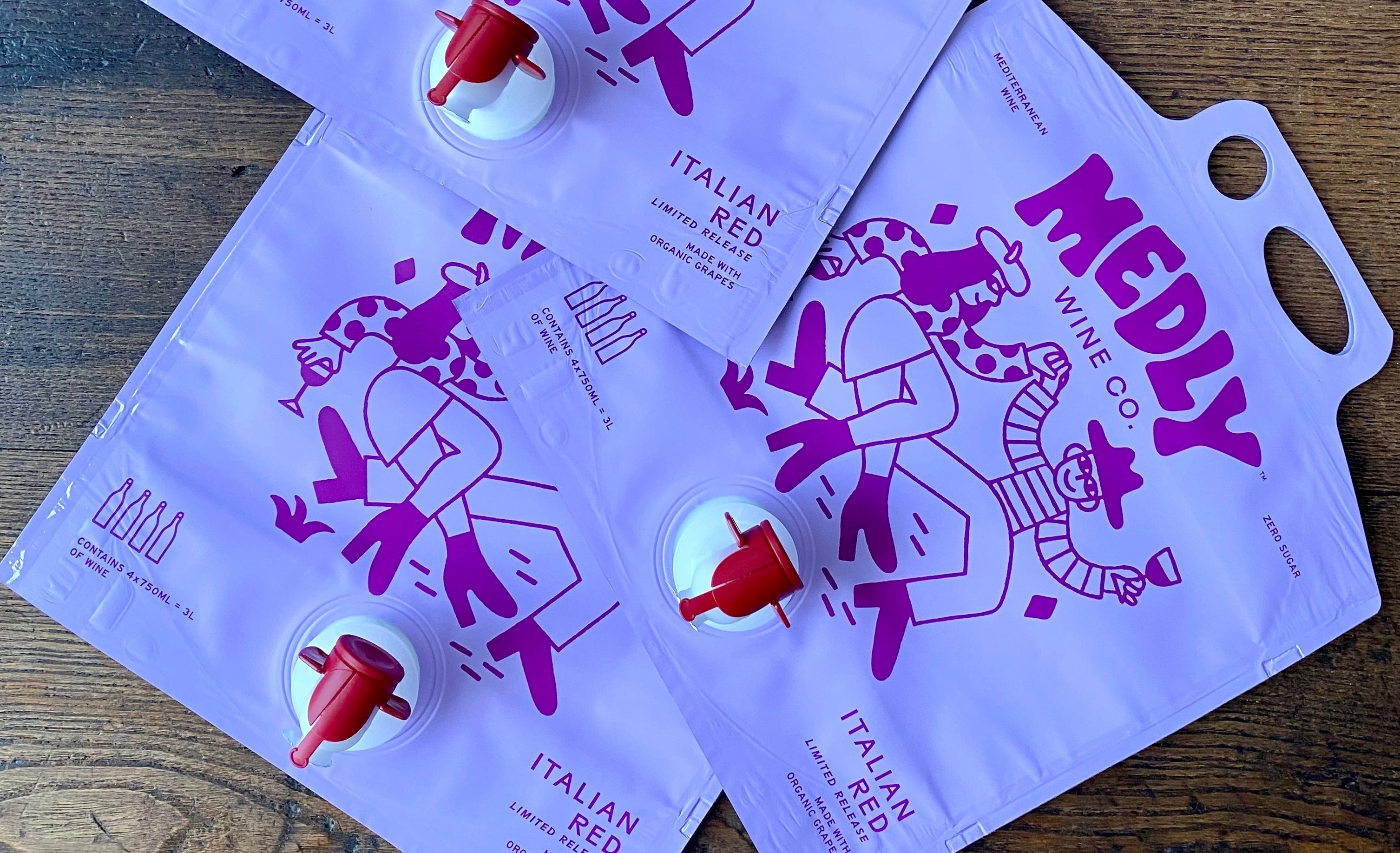 Medly’s Italian Barbera Wine ecofriendly pouches in a stack on a wood table.