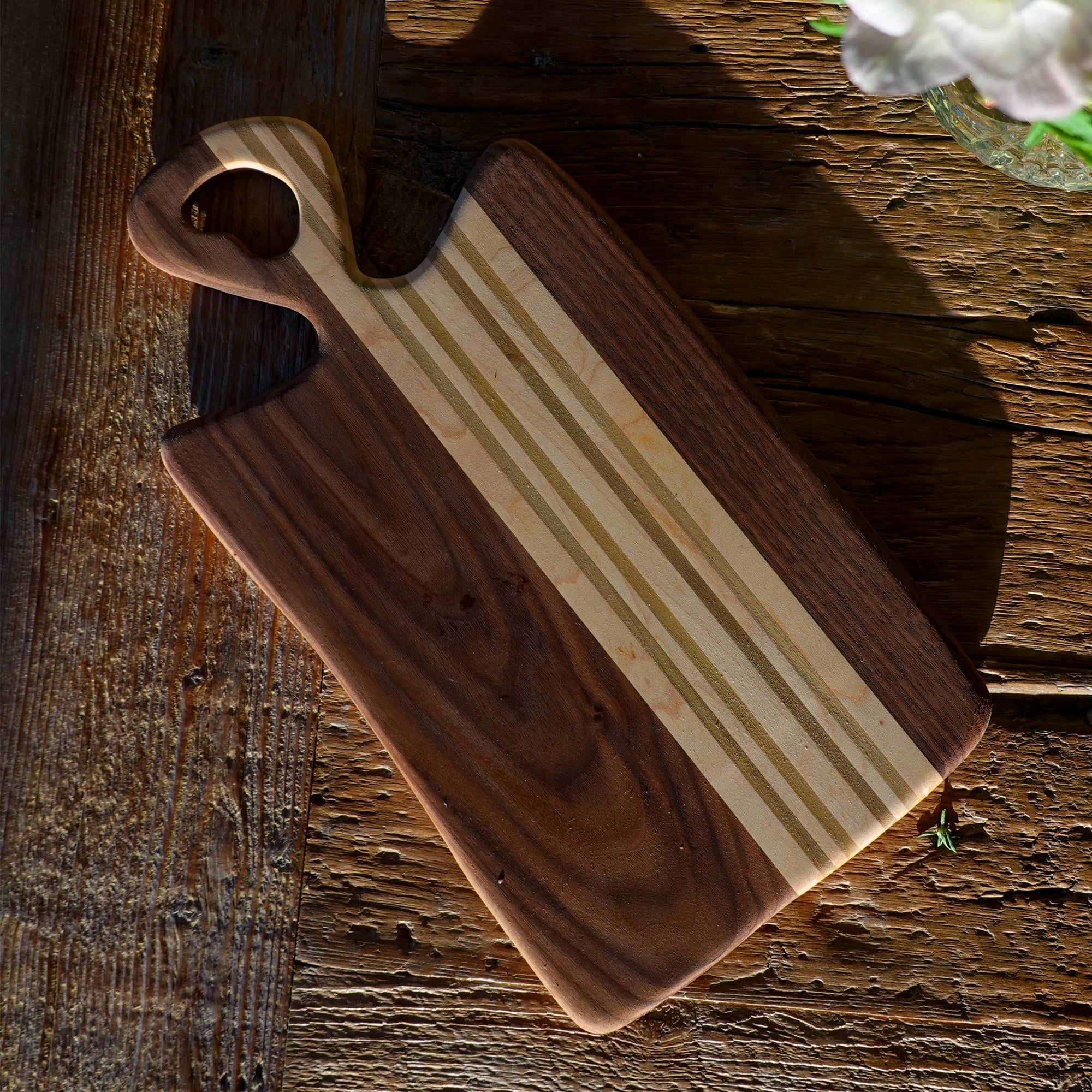 Wooden cutting board with striped pattern on a rustic wooden surface
